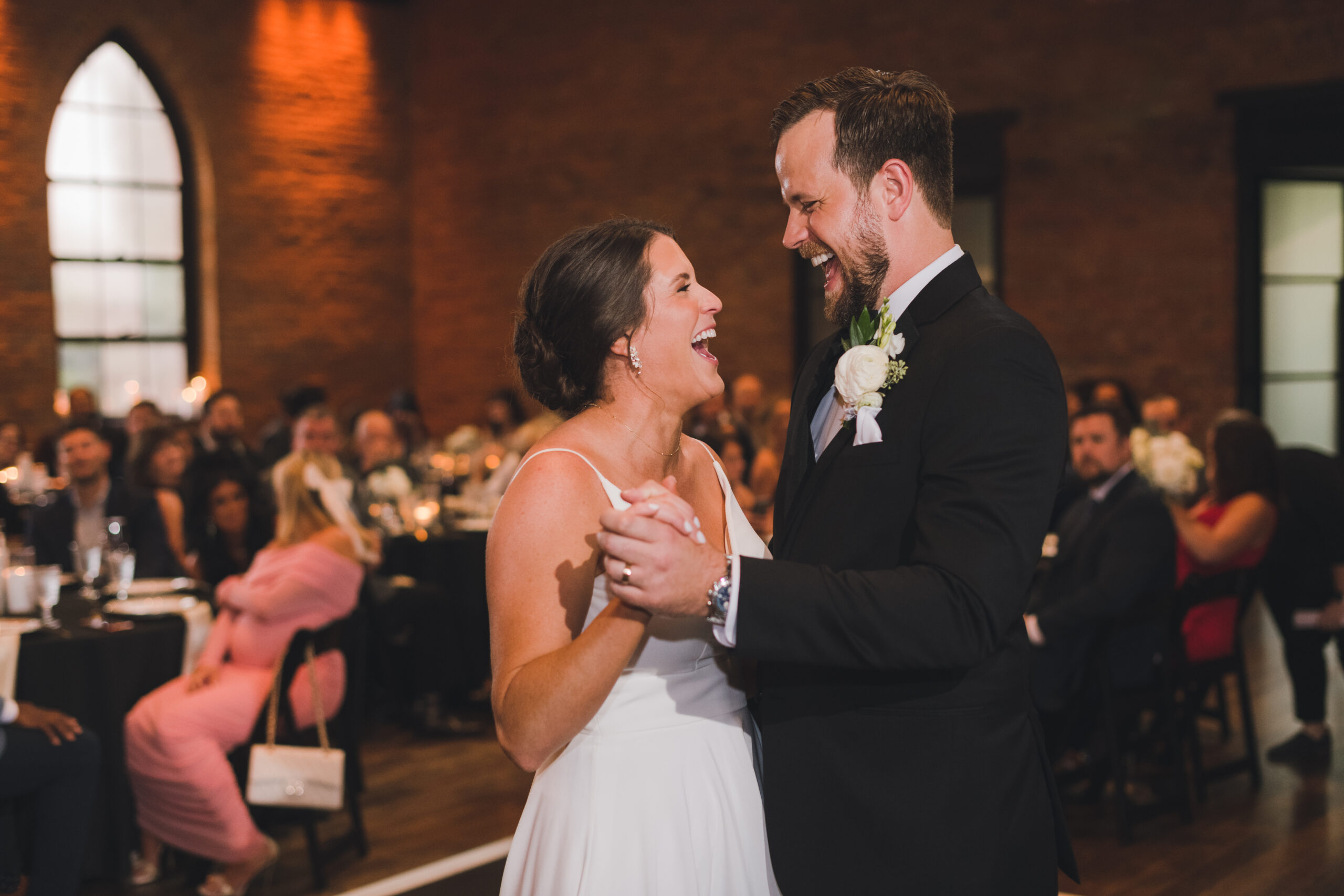 Bride and groom laughing during their first dance at the wedding reception
