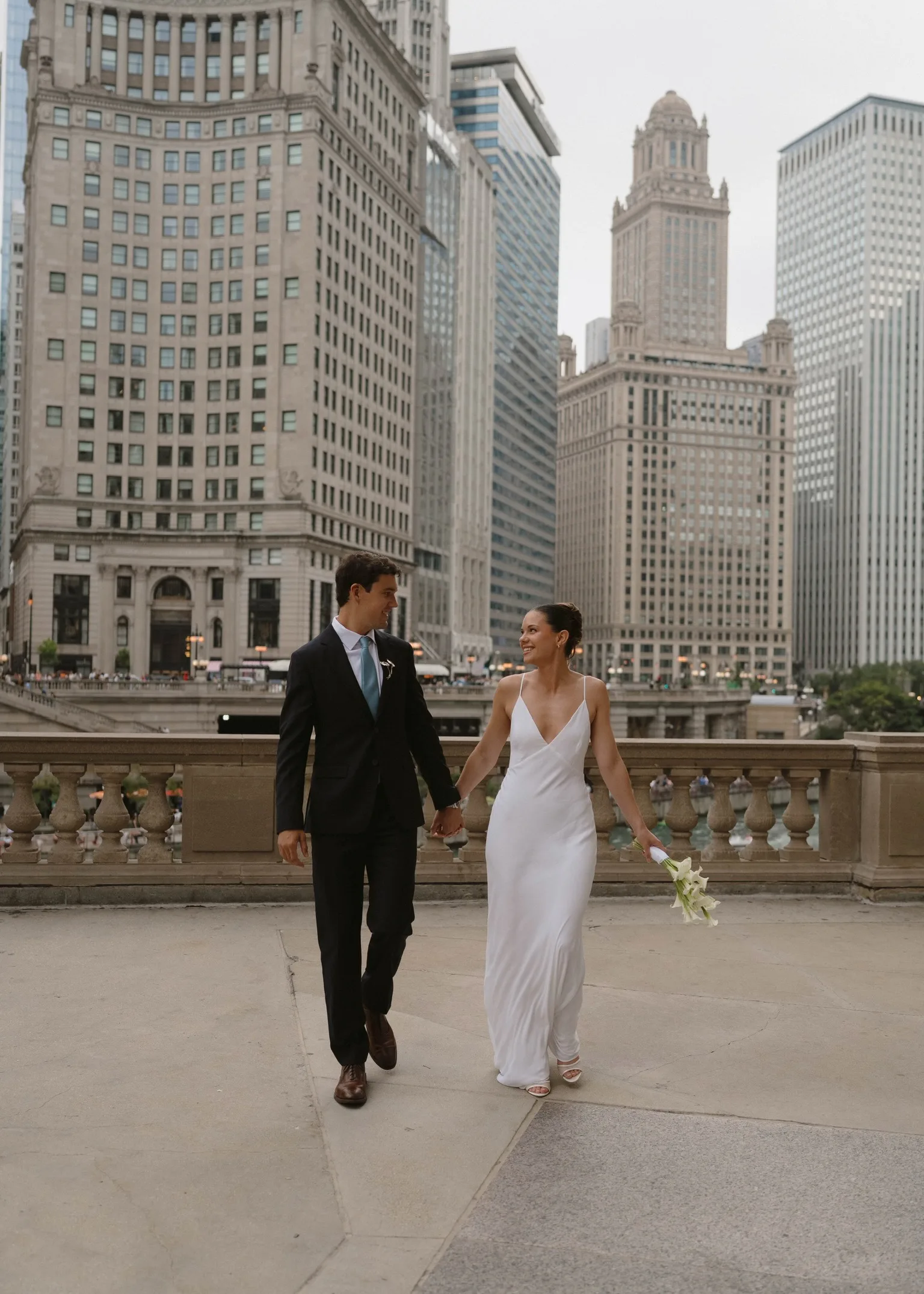 Newlyweds walking hand in hand on the Chicago Riverwalk